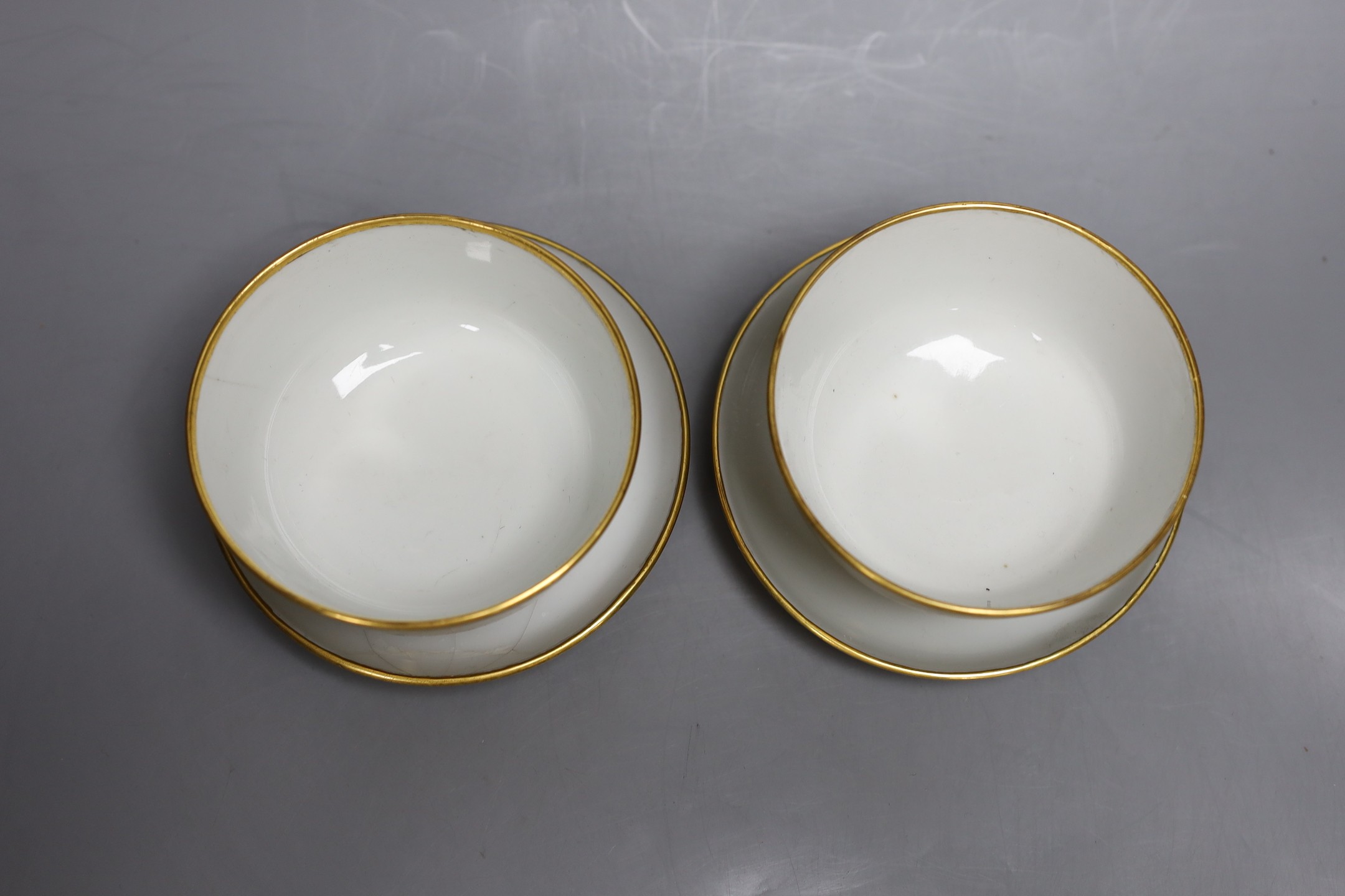 A pair of Paris porcelain gilded tea bowls and saucers , first half of 19th century, saucer 13cms diameter